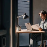 Small business owner reviewing loan approval documents on a laptop