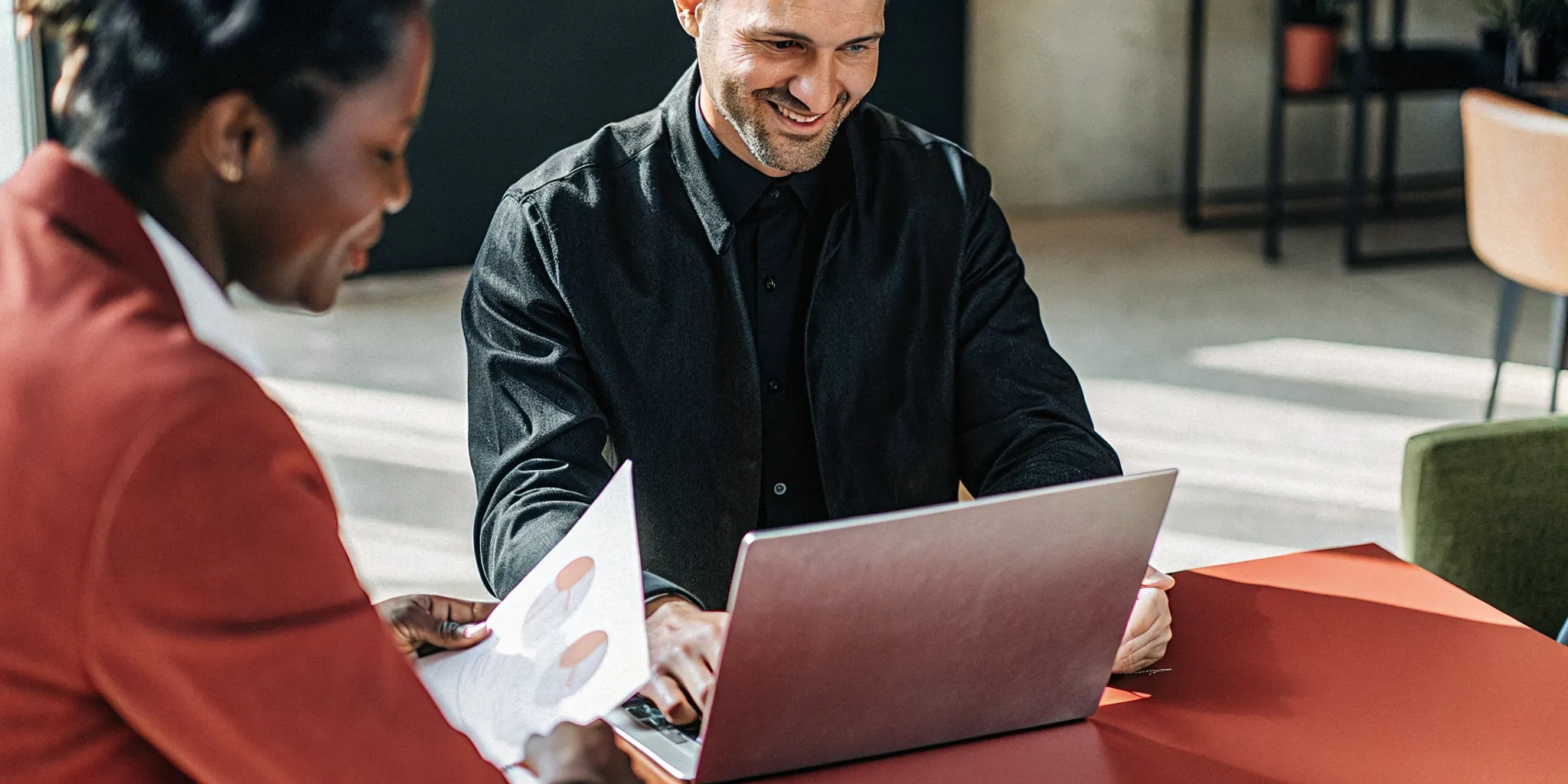 Small business owner reviewing documents at a desk with laptop