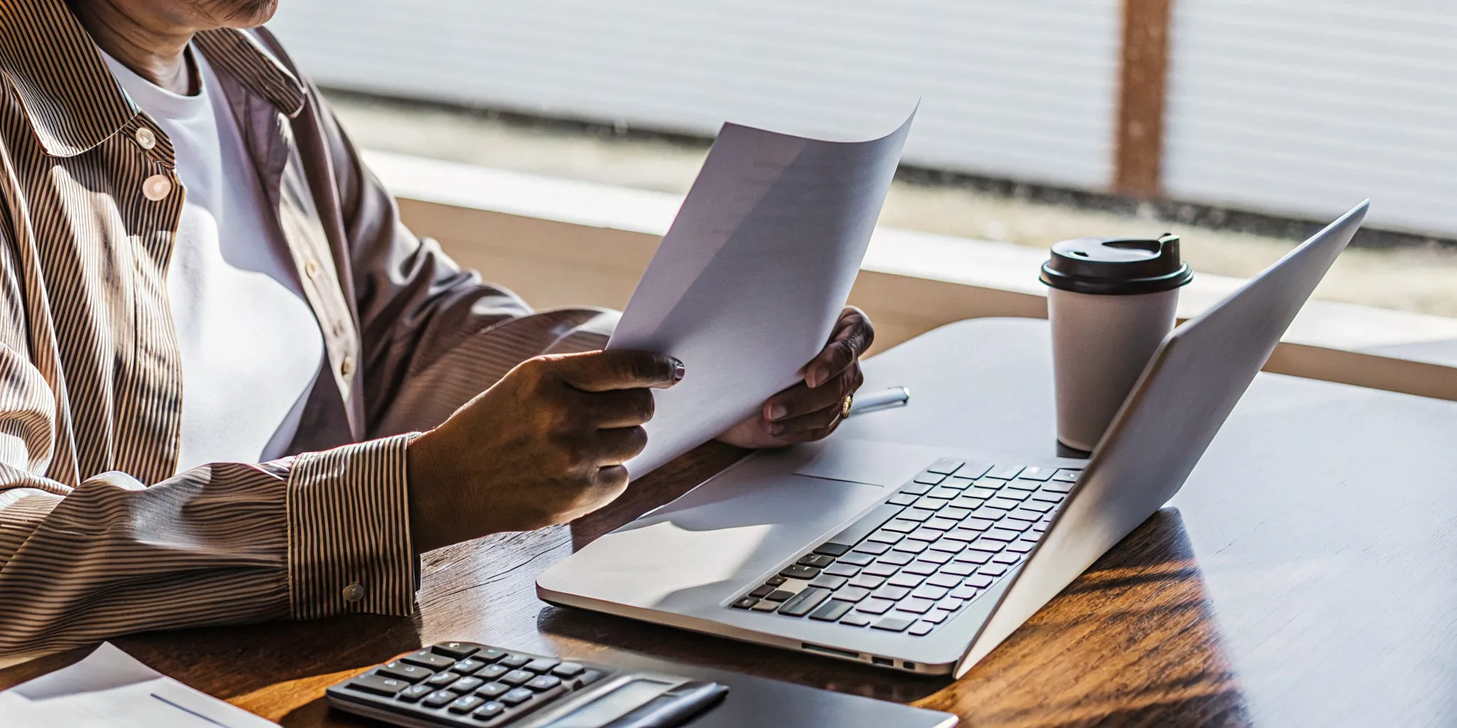 Small business owner reviewing revenue-based financing options on a laptop in a professional office setting