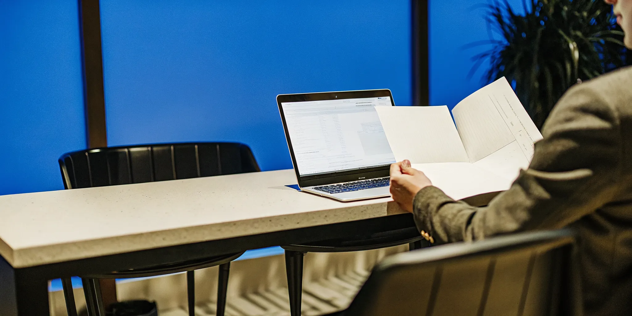 business-loan-no-collateral-how-to-get-unsecured-business-financing-161049 Small business owner reviewing paperwork at desk with laptop in modern office